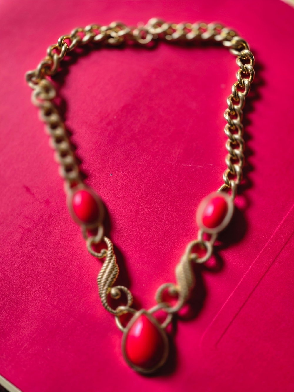 Vtg. Trifari gold toned metal necklace rope design, red plastic.